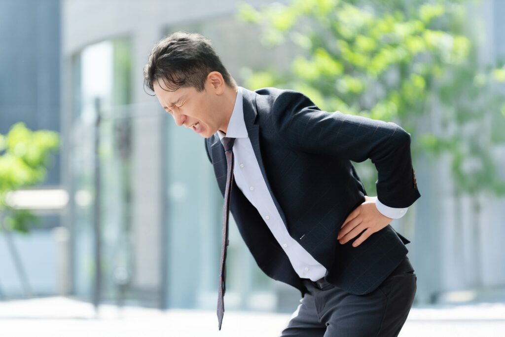 中腰姿勢で腰が痛い人のイメージ写真